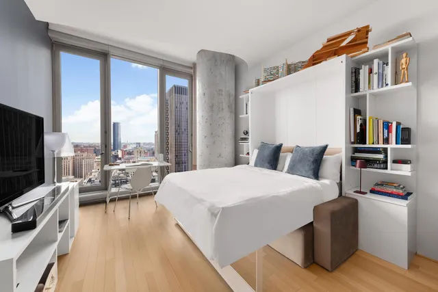 a bedroom with a bed and a large window