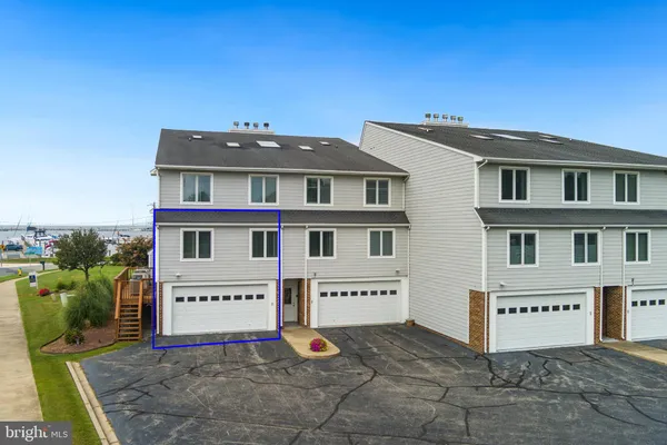 a view of a white house with large windows and a small yard