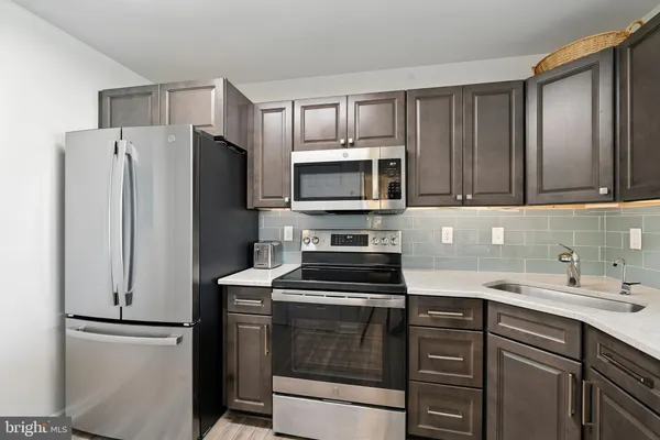 a kitchen with stainless steel appliances granite countertop a sink a stove and cabinets