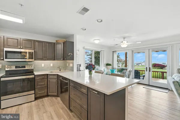 a kitchen with stainless steel appliances granite countertop a sink dishwasher stove and microwave with wooden cabinets