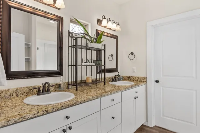 a bathroom with a granite countertop sink and a mirror