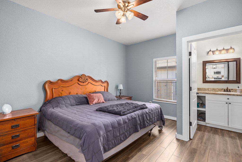 1922 Weston Loop Kerrville, TX 78028 - Photo 17 of 22 a bedroom with a bed dresser and wooden floor