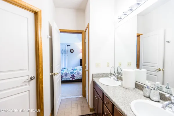a en suite bathroom with a granite countertop sink and a mirror