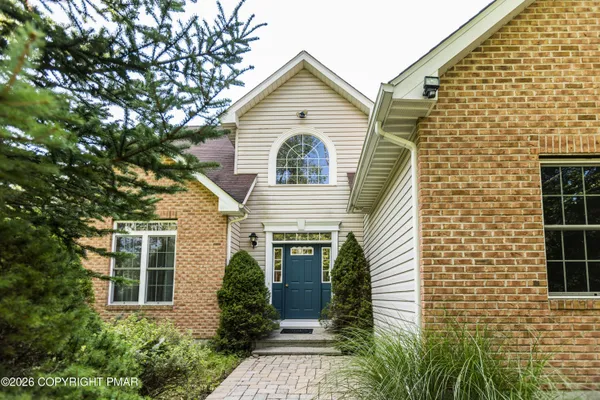 a view of a house with brick walls and potted plants