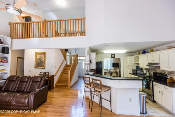 a living room with furniture a kitchen view and a chandelier