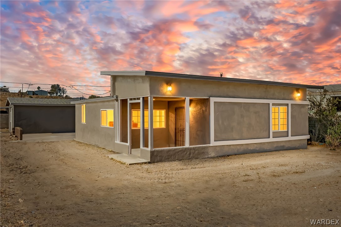 The property features a minimalist exterior with a flat roofline and sconce lighting