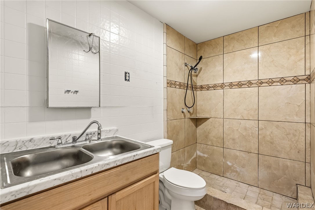 1628 Ramar Road Bullhead City, AZ 86442 - Photo 29 of 64 Casita - bathroom includes a dual stainless steel sink and a tiled shower with a decorative accent band