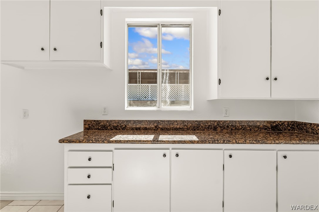 1628 Ramar Road Bullhead City, AZ 86442 - Photo 54 of 64 Kitchen featuring white cabinetry with dark hardware, a granite countertop, and a window providing natural light