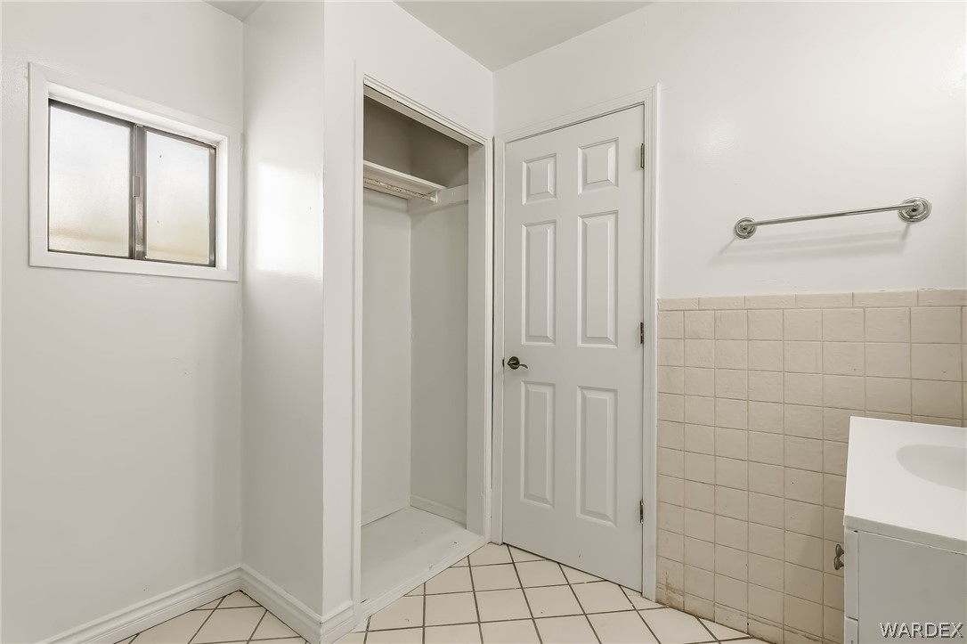 1628 Ramar Road Bullhead City, AZ 86442 - Photo 61 of 64 The property features a closet with shelving, a window, and tiled flooring