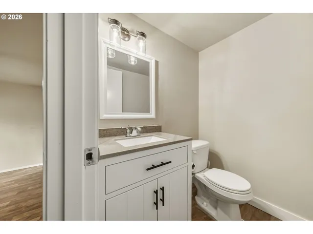 a bathroom with a granite countertop toilet sink and mirror