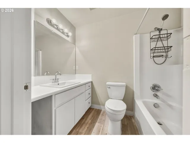 a bathroom with a toilet sink a mirror and shower