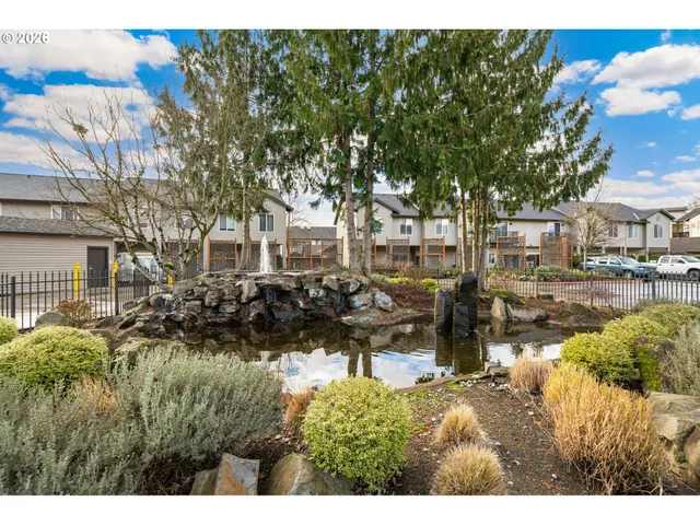 a view of swimming pool with outdoor seating and trees in the background