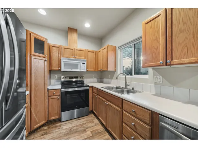 a kitchen with stainless steel appliances granite countertop a refrigerator and a sink