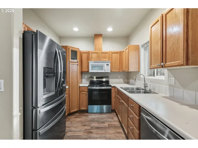 a kitchen with stainless steel appliances granite countertop a refrigerator stove and sink