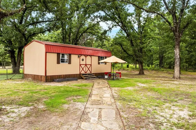a view of house with backyard and tree