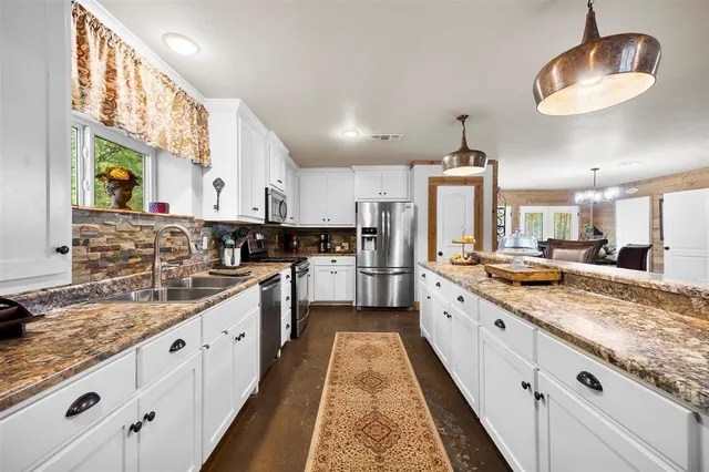 a large kitchen with granite countertop lots of counter space and sink