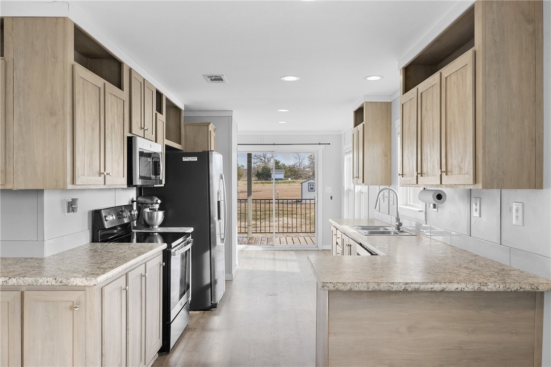 5236 County Road 219 Anderson, TX 77830 - Photo 10 of 35 a kitchen with stainless steel appliances granite countertop a sink stove and refrigerator