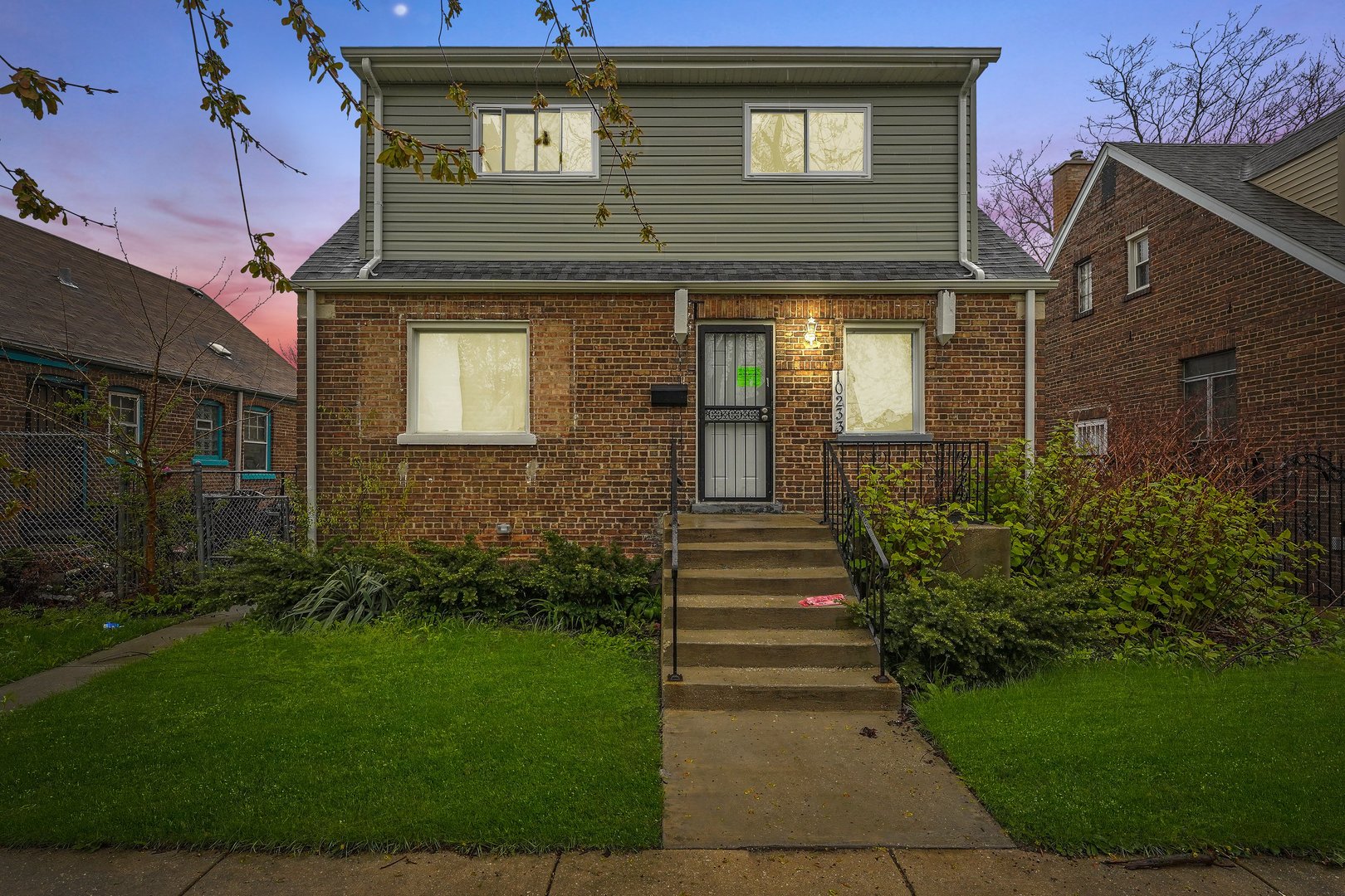 10233 South Calhoun Avenue Chicago, IL 60617 - Photo 1 of 22 a front view of a house with a garden