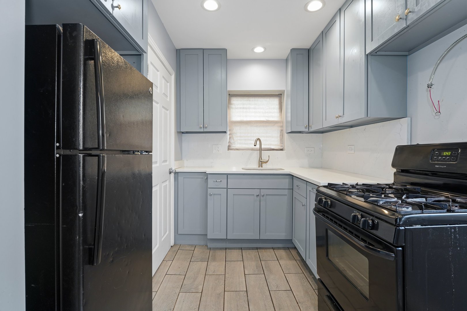 10233 South Calhoun Avenue Chicago, IL 60617 - Photo 12 of 22 a kitchen with a sink stove and refrigerator