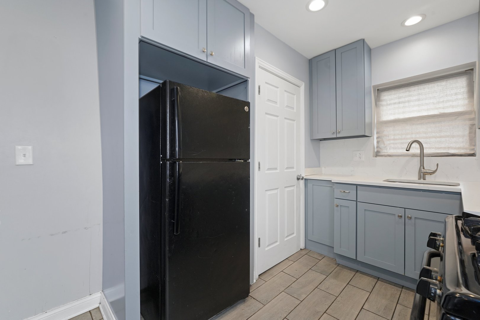 10233 South Calhoun Avenue Chicago, IL 60617 - Photo 13 of 22 a kitchen with a sink and refrigerator