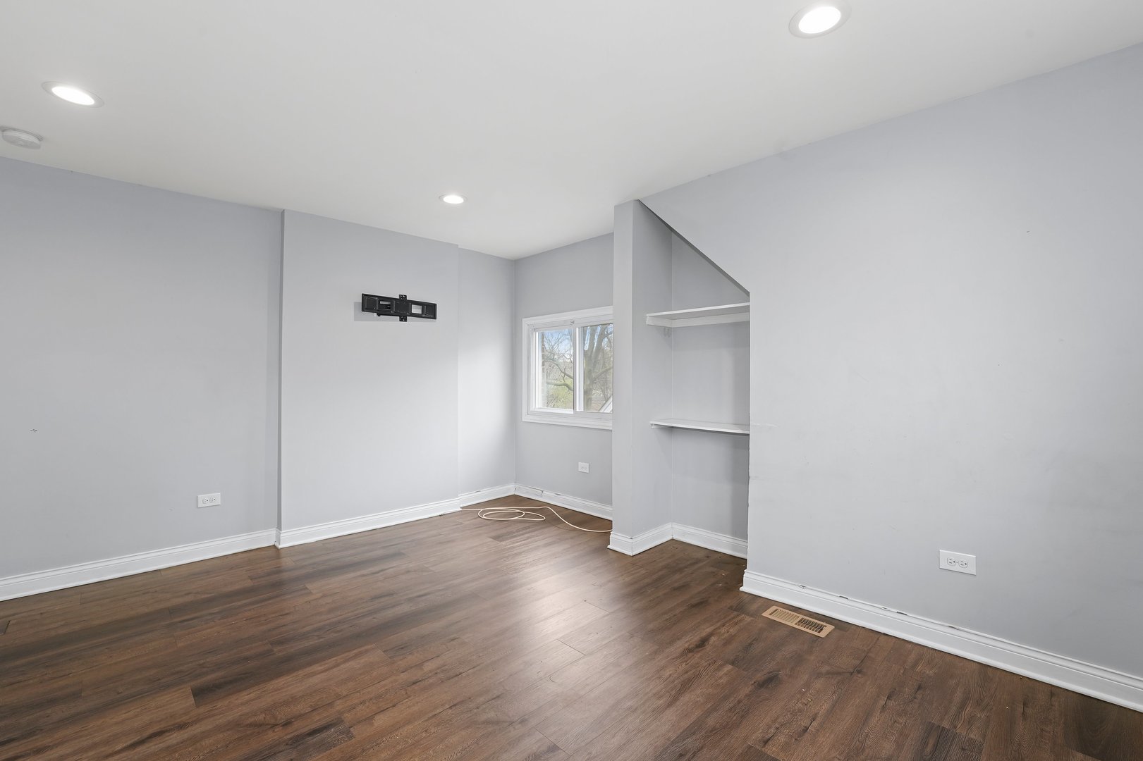 10233 South Calhoun Avenue Chicago, IL 60617 - Photo 18 of 22 a view of an empty room with wooden floor and a window