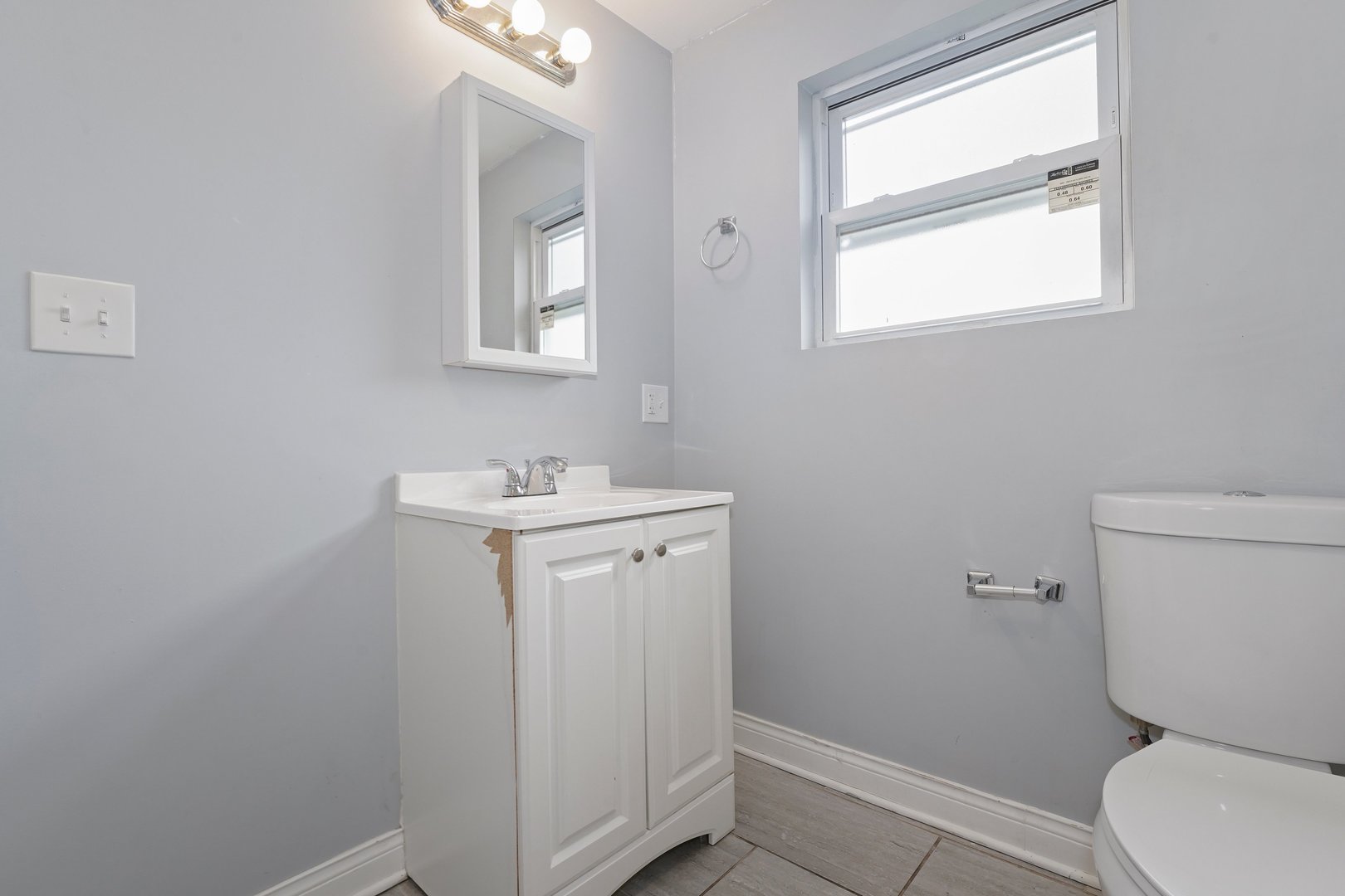 10233 South Calhoun Avenue Chicago, IL 60617 - Photo 20 of 22 a bathroom with a toilet sink and mirror
