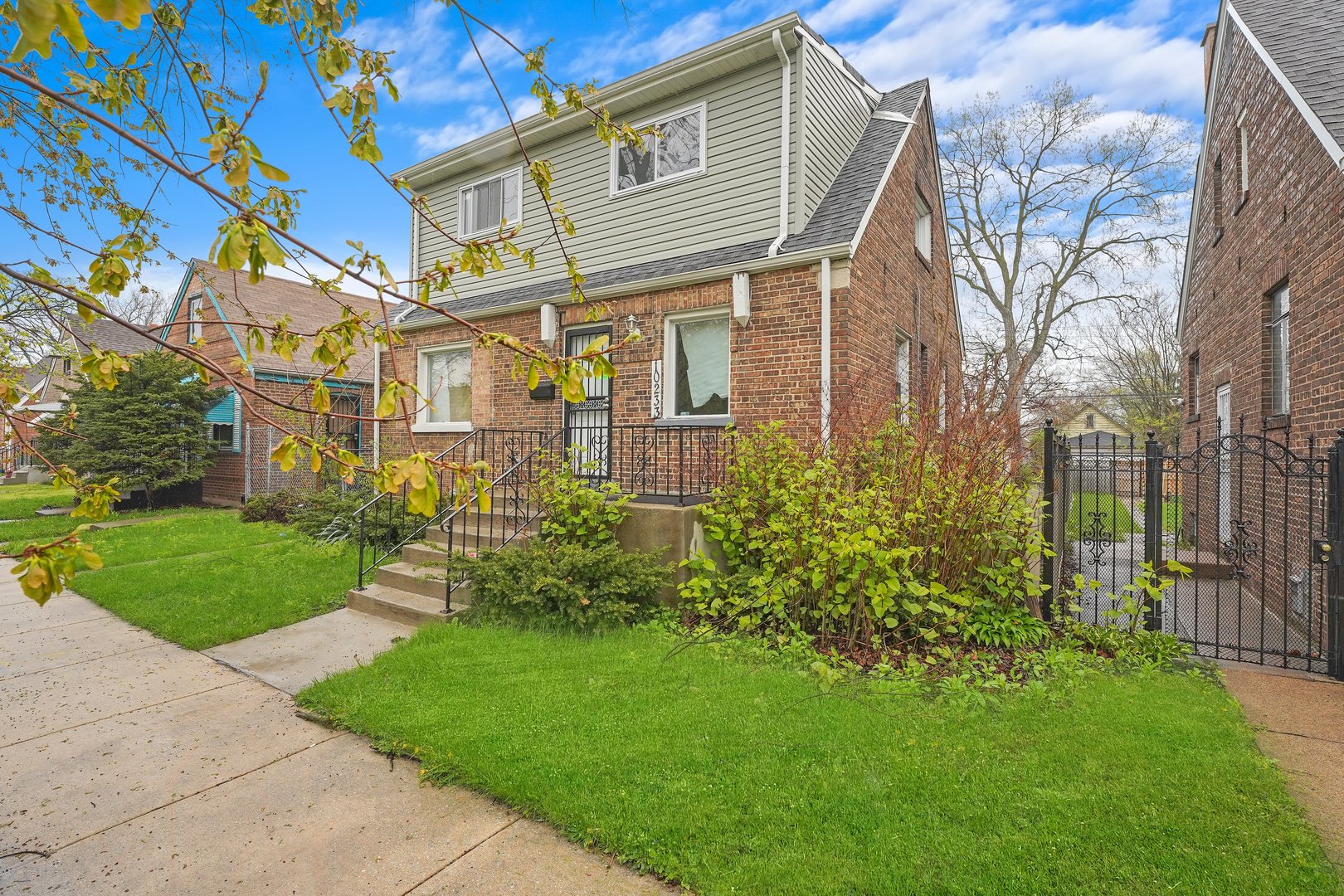 10233 South Calhoun Avenue Chicago, IL 60617 - Photo 5 of 22 a front view of a house with a garden