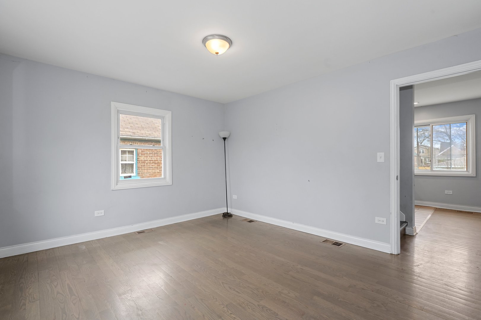 10233 South Calhoun Avenue Chicago, IL 60617 - Photo 6 of 22 an empty room with wooden floor and windows