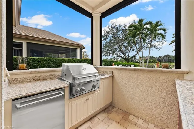 a patio with a table and chairs and a fire pit with the view of flower garden