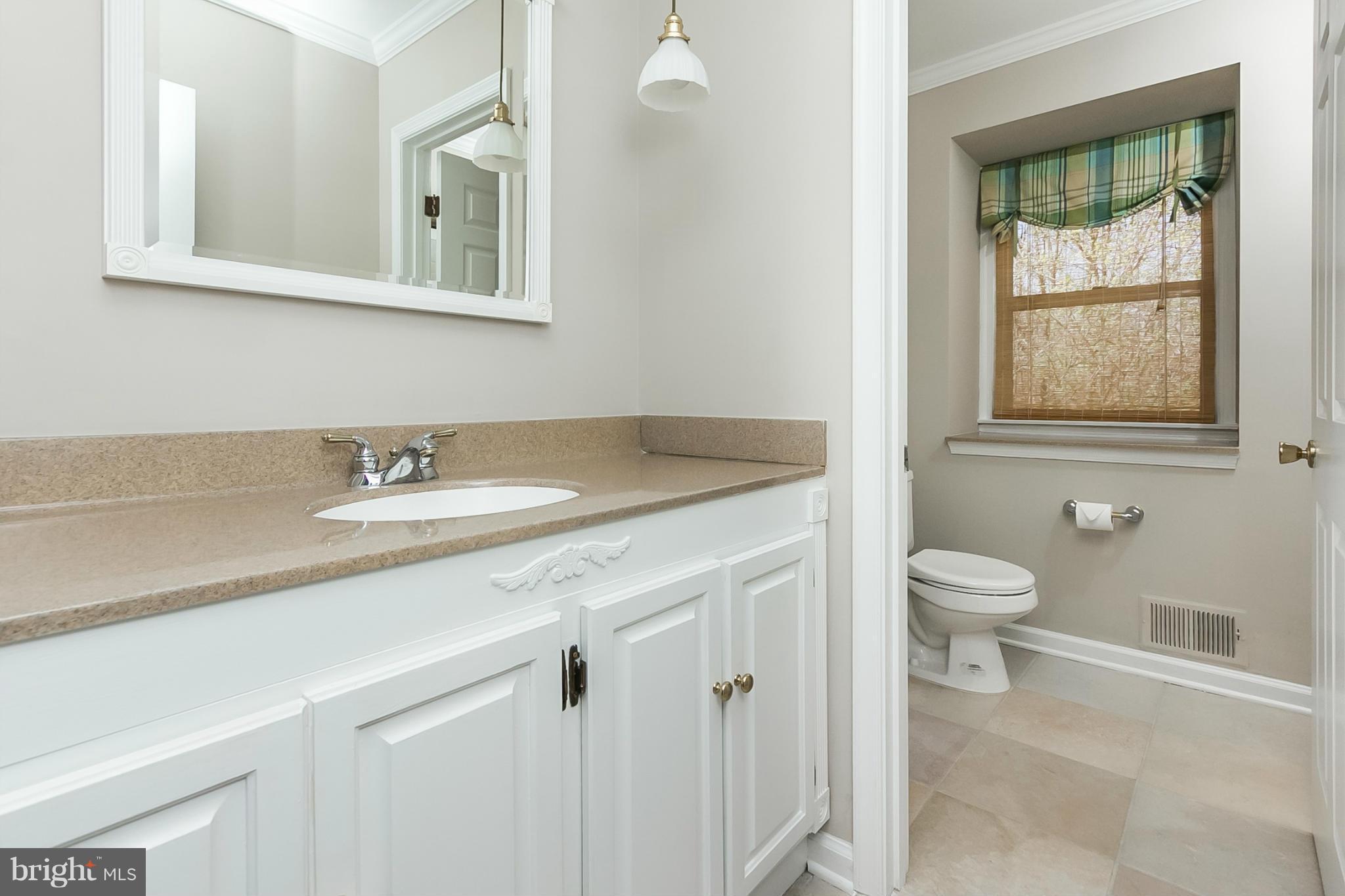 14106 Manor Road Phoenix, MD 21131 - Photo 22 of 30 a bathroom with a granite countertop sink a toilet and a window