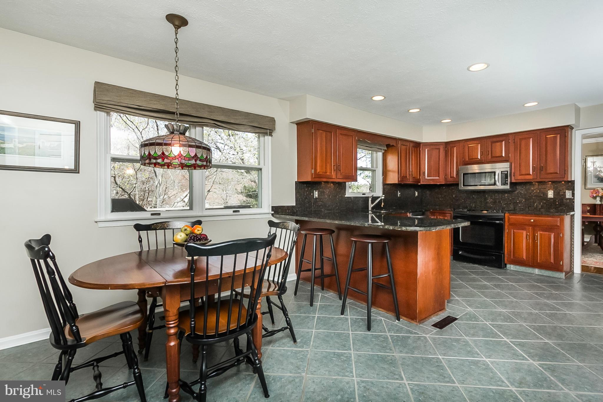 14106 Manor Road Phoenix, MD 21131 - Photo 10 of 30 a kitchen with stainless steel appliances granite countertop a stove a sink a kitchen island a dining table and chairs