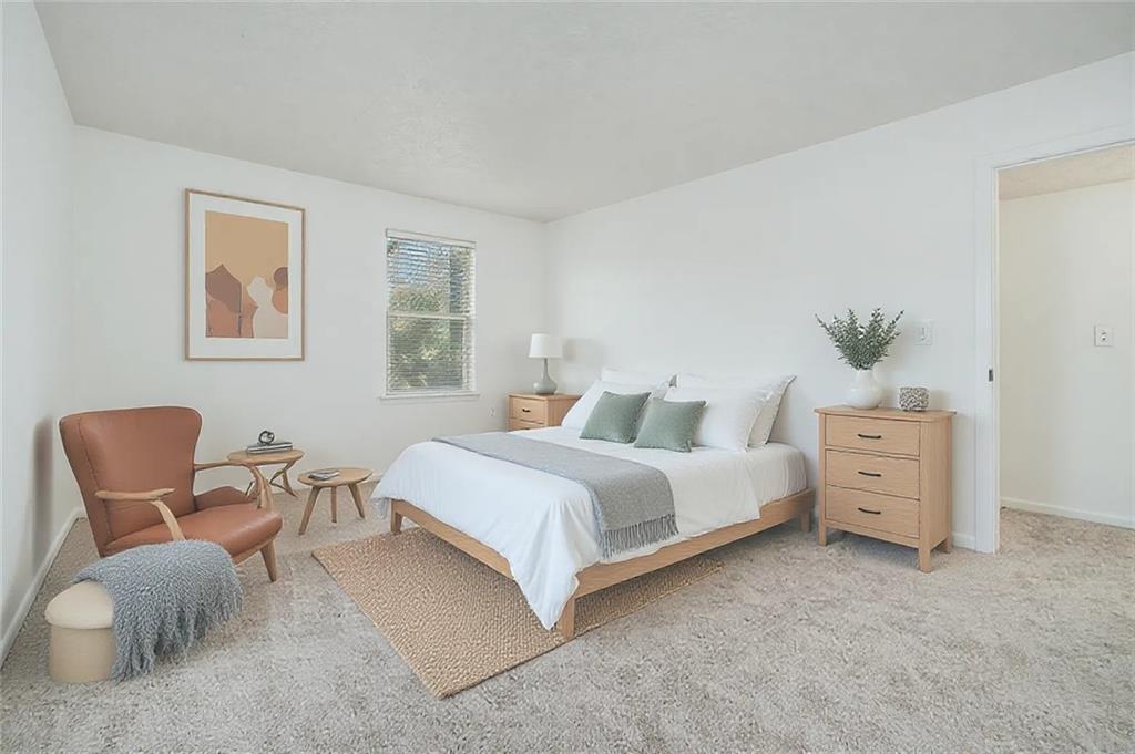 1150 Collier Road Northwest, Unit 12F Atlanta, GA 30318 - Photo 14 of 26 a bedroom with furniture and a chair