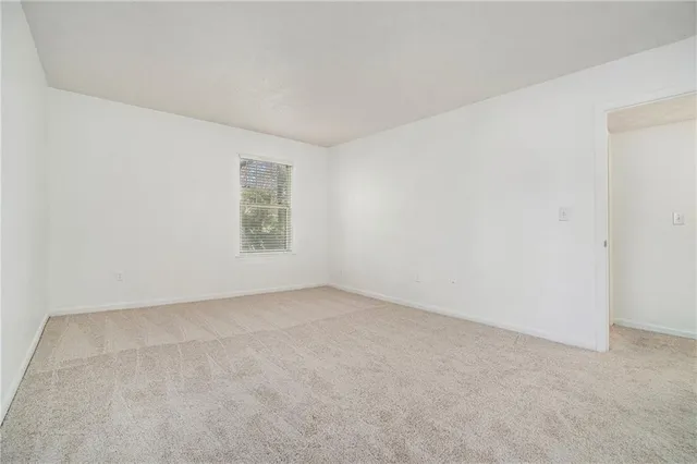 a spacious bedroom with a bed and a chair