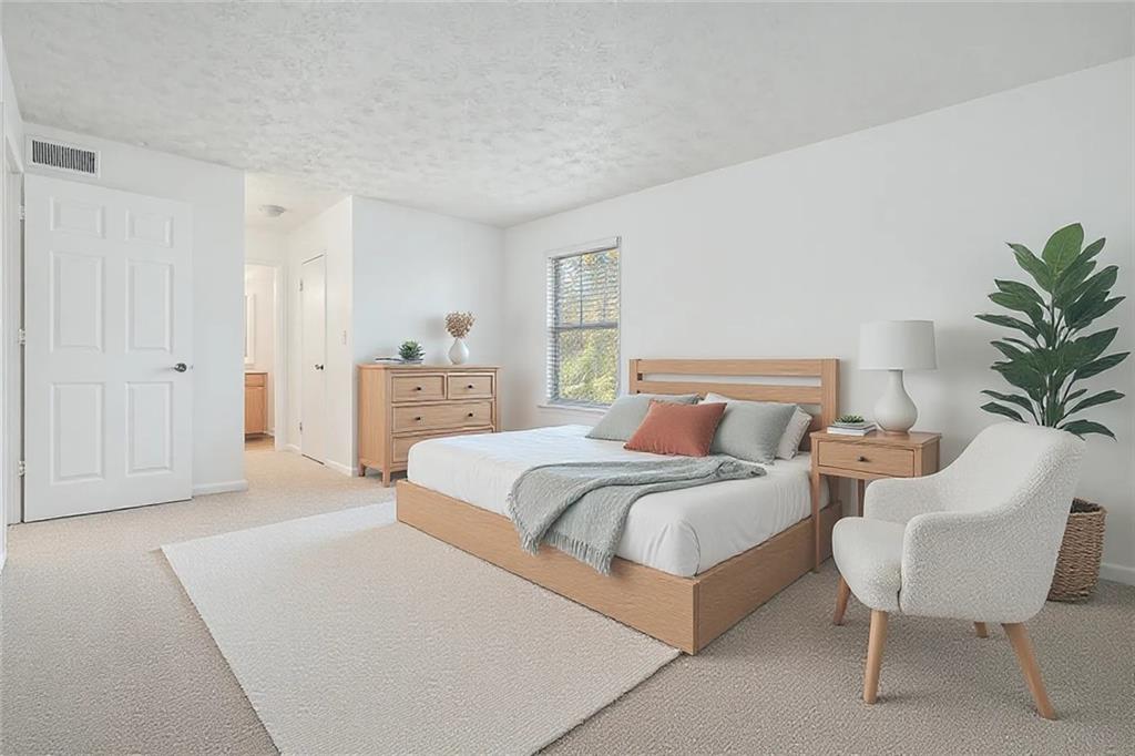 1150 Collier Road Northwest, Unit 12F Atlanta, GA 30318 - Photo 16 of 26 a spacious bedroom with a bed and a chair