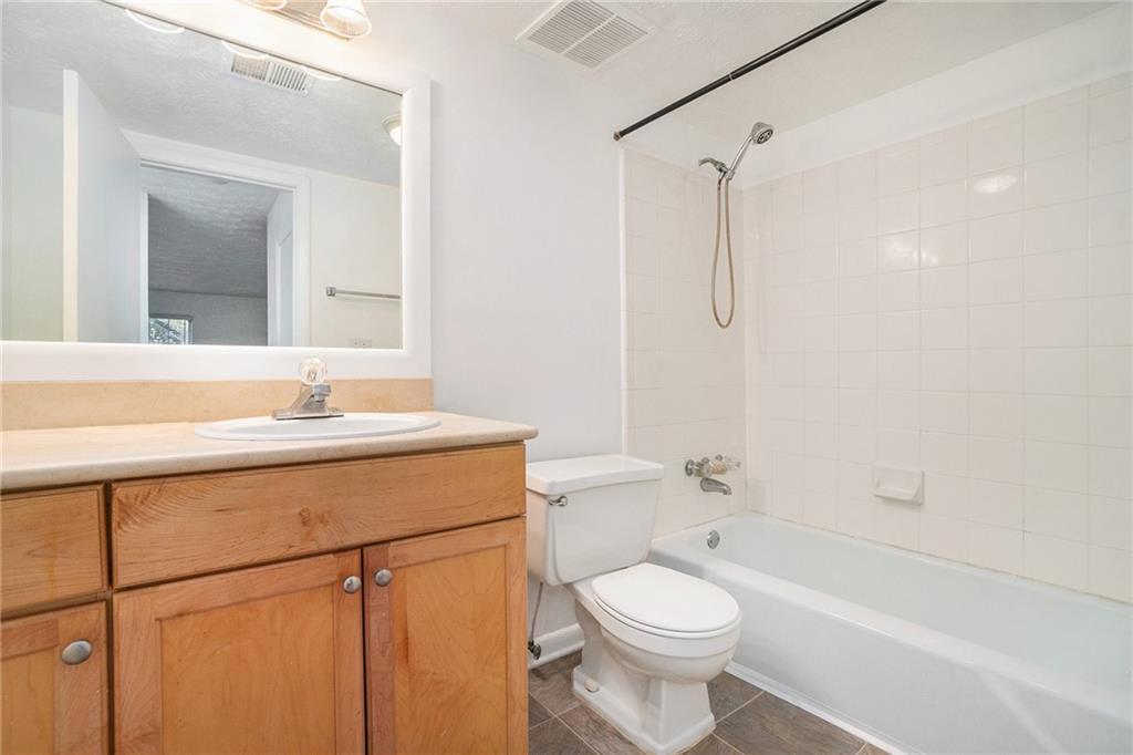 1150 Collier Road Northwest, Unit 12F Atlanta, GA 30318 - Photo 23 of 26 a bathroom with a sink a toilet and shower