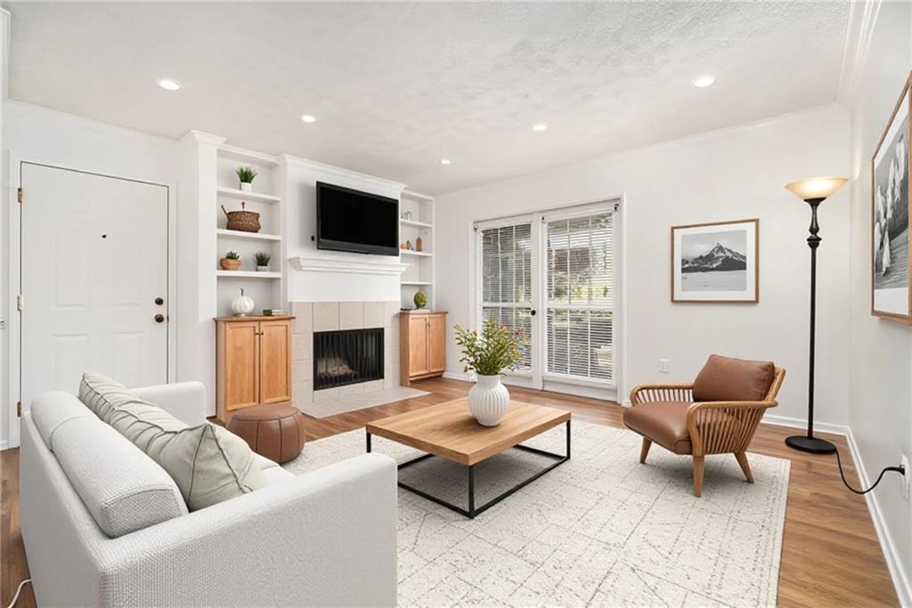 1150 Collier Road Northwest, Unit 12F Atlanta, GA 30318 - Photo 4 of 26 a living room with furniture a flat screen tv and a fireplace