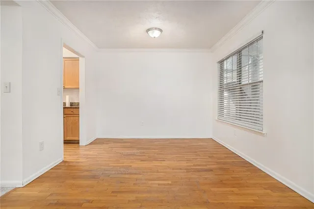 a view of empty room with wooden floor and window
