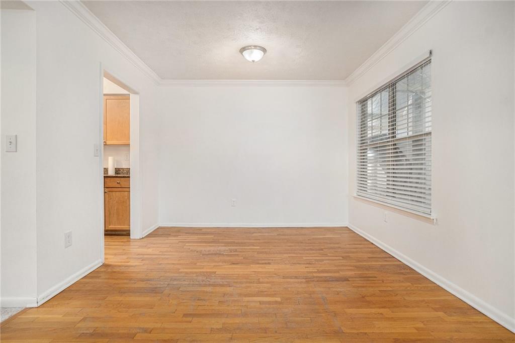 1150 Collier Road Northwest, Unit 12F Atlanta, GA 30318 - Photo 10 of 26 a view of an empty room with wooden floor and a window