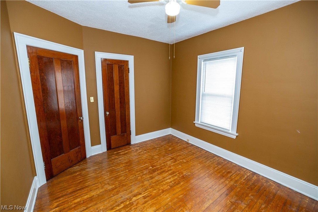 10105 Unity Avenue Cleveland, OH 44111 - Photo 9 of 35 Unfurnished bedroom featuring a textured ceiling, ceiling fan, and wood-type flooring