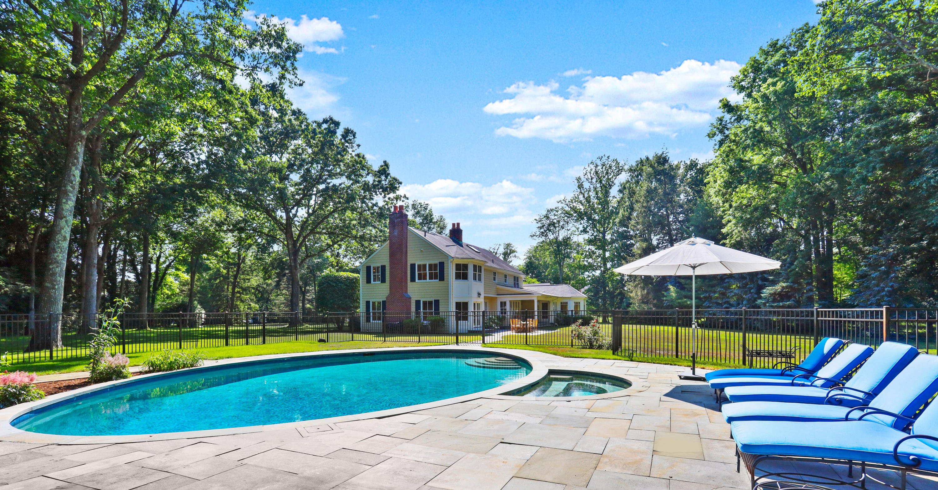 298 Brookside Road Darien, CT 06820 - Photo 1 of 36 a view of pool with lawn chairs under an umbrella