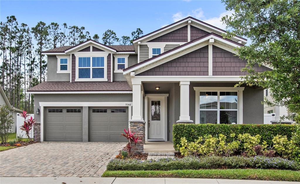 a front view of a house with garden and plants