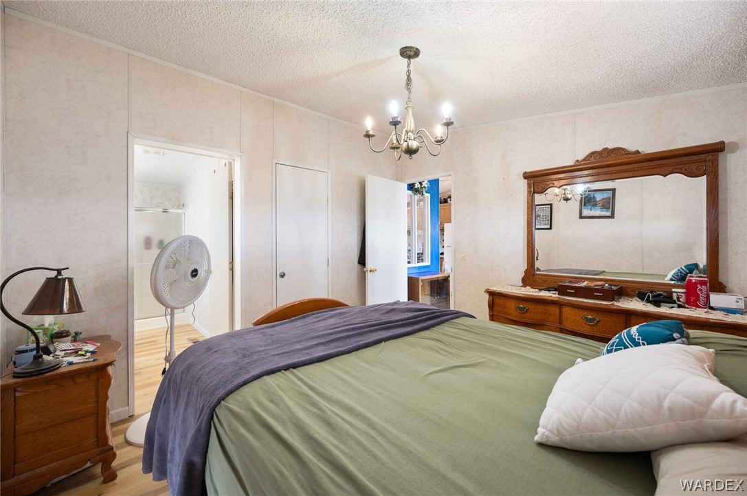 2465 Egar Road Golden Valley, AZ 86413 - Photo 30 of 98 This room features paneled walls and a chandelier, with a view into an adjoining bathroom that includes a shower