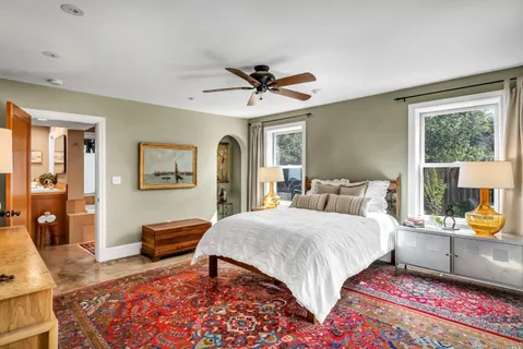 a bedroom with a bed a bookshelf and a chandelier