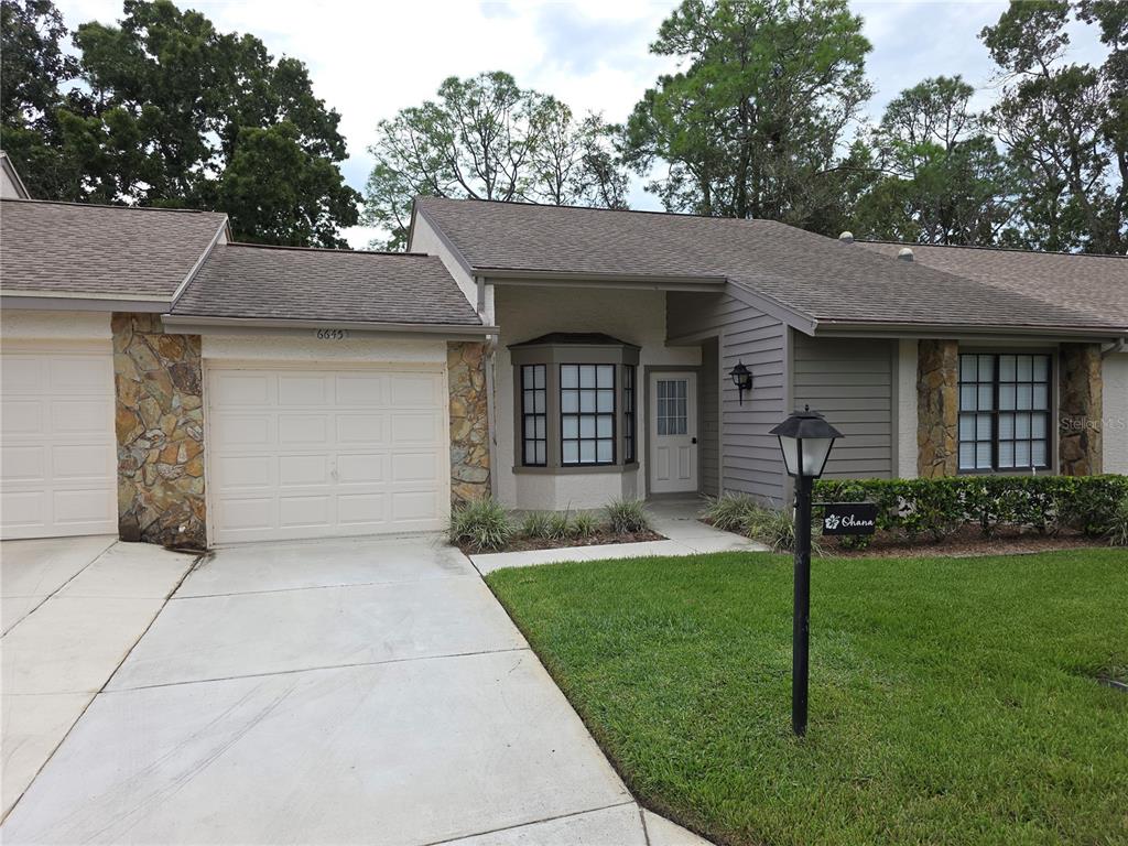 6645 Brambleleaf Drive Spring Hill, FL 34606 - Photo 1 of 1 a front view of a house with a yard and garage