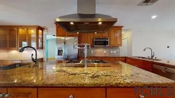 a kitchen with kitchen island granite countertop a sink counter top space and cabinets