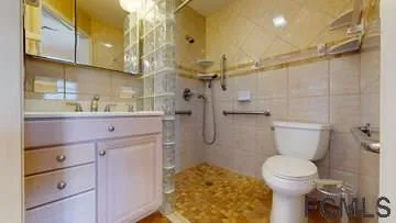 a bathroom with a sink a toilet and shower
