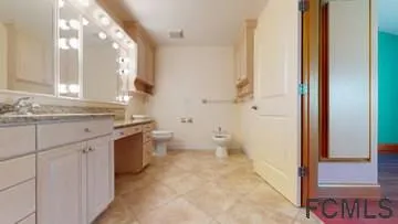 a bathroom with a double vanity sink toilet and shower