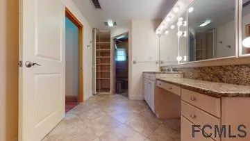 a bathroom with a granite countertop sink a mirror and a shower