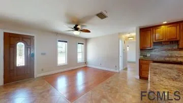a view of a hallway with wooden floor and a bathroom