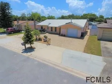 an aerial view of residential houses with outdoor space and trees